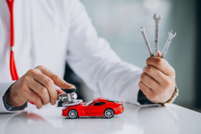 Free Photo _ Car technician with stethoscope in a car showroom